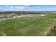 An aerial view shows multiple well-maintained sports fields with soccer goals and lights in a large complex with lush green grass at 14932 Amberjack Ter, Lakewood Ranch, FL 34202