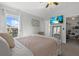 Relaxing bedroom features a mounted TV, access to walk-in closet, and decor at 14932 Amberjack Ter, Lakewood Ranch, FL 34202
