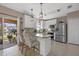 Bright kitchen features white cabinets, stainless steel appliances, island with counter seating and sliding door at 14932 Amberjack Ter, Lakewood Ranch, FL 34202