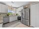 Well-lit kitchen with stainless steel appliances, granite counters, white cabinets and neutral tile floors at 14932 Amberjack Ter, Lakewood Ranch, FL 34202