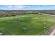 Aerial view of well-maintained soccer fields with nets, lighting and lake in the background at 14932 Amberjack Ter, Lakewood Ranch, FL 34202