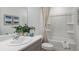 Well-lit bathroom featuring white cabinets, a shower with curtains, and a white toilet at 15101 Cuzcorro Ct, Nokomis, FL 34275