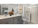 Modern bathroom featuring double sinks, grey cabinets and a glass-enclosed shower at 15101 Cuzcorro Ct, Nokomis, FL 34275