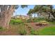 Community picnic area featuring multiple wooden picnic tables and lush landscaping for resident enjoyment at 15101 Cuzcorro Ct, Nokomis, FL 34275