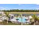 An aerial view of a stunning resort-style pool with cabanas, lounge chairs, and lush landscaping at 15109 Cuzcorro Ct, Nokomis, FL 34275