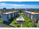 Aerial view of condo buildings with central pool, lush landscaping, and a waterfront setting at 1600 1St W Ave # 102A, Bradenton, FL 34205