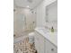 Modern bathroom featuring a glass-enclosed shower, hexagon tile floor, and white vanity with a rectangular mirror at 1600 1St W Ave # 102A, Bradenton, FL 34205