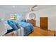 Bright bedroom featuring a ceiling fan, hardwood floors, and a view of the water at 1600 1St W Ave # 102A, Bradenton, FL 34205