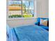 Inviting bedroom featuring a serene view of the water, plush bedding, and a comfortable blue chair at 1600 1St W Ave # 102A, Bradenton, FL 34205