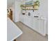 Bright dining area featuring white cabinets and floating shelves adorned with decorative items at 1600 1St W Ave # 102A, Bradenton, FL 34205