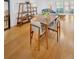 Sunlit dining area featuring a wood table with seating, wood floors, and stylish shelving at 1600 1St W Ave # 102A, Bradenton, FL 34205