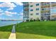 Waterfront condo building featuring well-manicured lawn, lush landscaping, and water views at 1600 1St W Ave # 102A, Bradenton, FL 34205