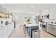 Bright kitchen featuring white cabinets, stainless steel appliances, island with bar seating, and tile flooring at 1600 1St W Ave # 102A, Bradenton, FL 34205