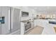 Modern kitchen featuring stainless appliances, marble countertops, and white cabinetry at 1600 1St W Ave # 102A, Bradenton, FL 34205