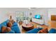 Bright living room with wood floors, a blue sofa, and sliding glass doors leading to the outside at 1600 1St W Ave # 102A, Bradenton, FL 34205