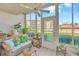 Bright sunroom with tile floor, ceiling fan, tropical decor and view of well maintained community lawn at 1600 1St W Ave # 102A, Bradenton, FL 34205