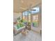 Bright sunroom with floor-to-ceiling windows, a ceiling fan, and a comfortable wicker sofa with tropical-themed pillows at 1600 1St W Ave # 102A, Bradenton, FL 34205
