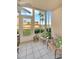 Inviting sunroom with large windows showcasing waterfront views, wicker chairs and tropical-themed pillows at 1600 1St W Ave # 102A, Bradenton, FL 34205
