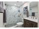 Modern bathroom features a marble tiled walk-in shower with glass door and dark wood vanity at 1620 Boathouse Cir # 101, Sarasota, FL 34231