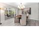 Stylish dining room with modern chandelier, round table, and chairs, next to a window with seating area at 1620 Boathouse Cir # 101, Sarasota, FL 34231