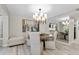 Bright dining room with modern chandelier, round table, seating for six, and a mirrored wall feature at 1620 Boathouse Cir # 101, Sarasota, FL 34231