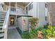 Exterior view of a building featuring a staircase, greenery, and an outdoor storage closet with fire extinguisher at 1620 Boathouse Cir # 101, Sarasota, FL 34231