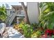 Inviting exterior view of a two-story building with lush landscaping, a staircase, and a peek of a car on the left at 1620 Boathouse Cir # 101, Sarasota, FL 34231