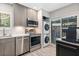 Contemporary kitchen with stainless steel appliances, gray cabinets, and access to the patio with laundry at 1620 Boathouse Cir # 101, Sarasota, FL 34231