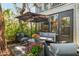 Charming outdoor patio with comfortable furniture, vibrant flowers, and shade from a large umbrella at 1620 Boathouse Cir # 101, Sarasota, FL 34231