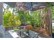 Cozy outdoor patio area with comfortable seating surrounded by lush tropical landscaping at 1620 Boathouse Cir # 101, Sarasota, FL 34231