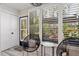 Charming sun room with cozy seating, shuttered windows, and views of the lush garden and patio at 1620 Boathouse Cir # 101, Sarasota, FL 34231