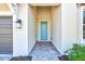 The front entrance features a stylish teal door and brick pavers at 16816 Seraphic Trl, Lakewood Ranch, FL 34211