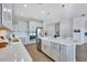 Well-lit kitchen with stainless steel appliances, white cabinets, light countertops, and farmhouse sink in an island at 16816 Seraphic Trl, Lakewood Ranch, FL 34211