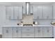 Modern kitchen with white cabinets, stainless steel appliances, and white subway tile backsplash for cooking at 16816 Seraphic Trl, Lakewood Ranch, FL 34211