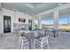 Covered outdoor living space with stone fireplace, comfortable seating, and open views at 16816 Seraphic Trl, Lakewood Ranch, FL 34211