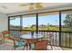Relaxing lanai with wicker furniture and a table, offering views of the serene waterfront at 1783 Lake Pl # 1783C, Venice, FL 34293
