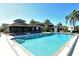 Community pool with clear blue water, shaded lounge area, and well-maintained deck with lush tropical landscaping at 1783 Lake Pl # 1783C, Venice, FL 34293