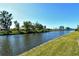Relaxing water view featuring lush green shoreline under a clear blue sky, homes in the background at 1783 Lake Pl # 1783C, Venice, FL 34293