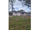 View of a backyard featuring green grass, trees, and some hardscape elements at 1807 27Th W St, Bradenton, FL 34205