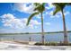 Stunning lake view with a scenic dock, benches, and palm trees surrounding the edge of the lake at 19912 Bridgetown Loop, Venice, FL 34293