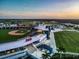 Aerial view of the sports park featuring a baseball stadium, green fields and modern facilities at sunset at 19912 Bridgetown Loop, Venice, FL 34293
