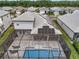 Drone view of a house with a pool and solar panels in a scenic neighborhood surrounded by lush greenery at 19912 Bridgetown Loop, Venice, FL 34293