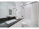 Modern bathroom featuring a granite vanity with white cabinets, soaking tub, and modern fixtures at 19912 Bridgetown Loop, Venice, FL 34293