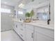 Bathroom featuring double vanity with white cabinets and marble floors adjacent to a marble shower at 19912 Bridgetown Loop, Venice, FL 34293