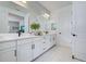 Bright bathroom featuring a double vanity with white cabinets and marble floors at 19912 Bridgetown Loop, Venice, FL 34293