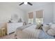 Bedroom featuring a ceiling fan, neutral colors, wood-look flooring, and abundant natural light at 19912 Bridgetown Loop, Venice, FL 34293