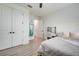 Bright bedroom with wood-look floors, a comfortable bed, and a green hammock at 19912 Bridgetown Loop, Venice, FL 34293