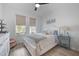 Bedroom featuring a ceiling fan, neutral colors, wood-look flooring, and abundant natural light at 19912 Bridgetown Loop, Venice, FL 34293