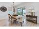 Bright dining area with a wooden table, modern lighting, and views of the screened-in pool area at 19912 Bridgetown Loop, Venice, FL 34293