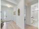 Inviting entryway with light wood floors, stylish decor and access to a full bathroom at 19912 Bridgetown Loop, Venice, FL 34293